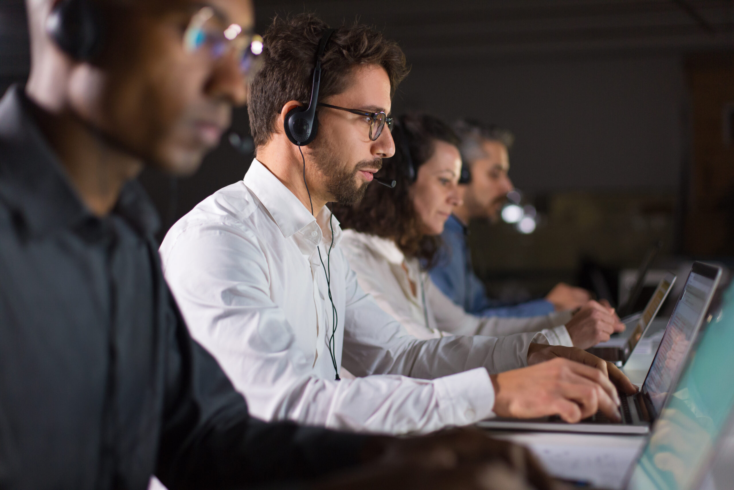 Side view of confident call center operator talking with client Team Kopter International